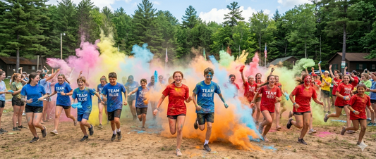 Two teams of summer camp kids in red and blue team shirts running through clouds of colorful powder during a color war event